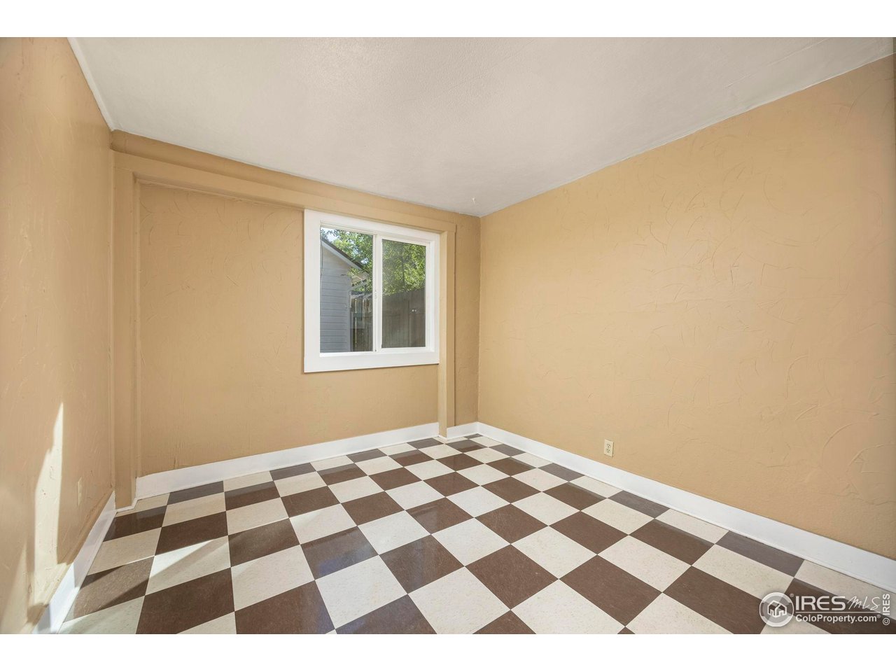 1623 12th Street Greeley, CO 80631 - Photo 28 of 30 a bedroom with a black and white checkered floor