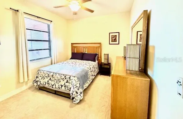 a bedroom with a bed dresser and a flat tv screen