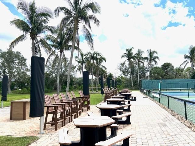 24417 Baltic Avenue, Unit 1102 Punta Gorda, FL 33955 - Photo 41 of 53 a view of a patio with a dining table and chairs with a fire pit