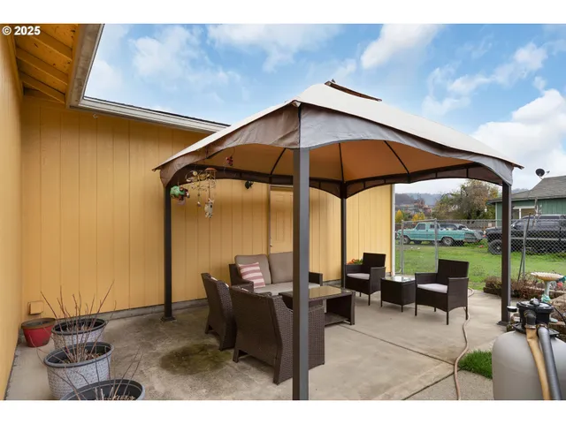 a backyard of a house with table and chairs