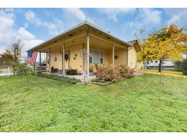 a view of a house with a small yard and wooden fence