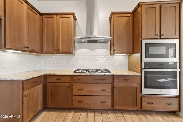 a kitchen with granite countertop white cabinets and stainless steel appliances