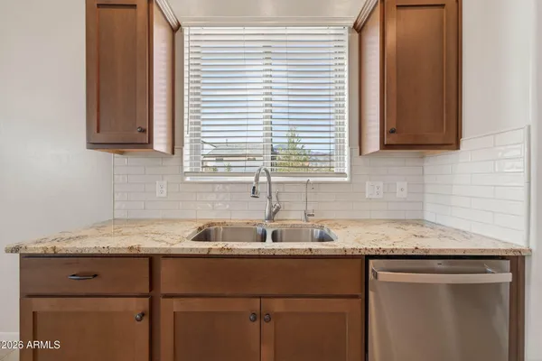 a kitchen with granite countertop cabinets sink and window