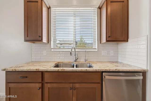 a kitchen with granite countertop cabinets sink and window