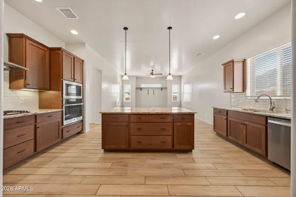 a kitchen with stainless steel appliances granite countertop a sink counter space cabinets and a large window