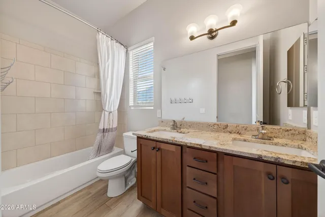 a bathroom with a granite countertop toilet a sink and a bathtub