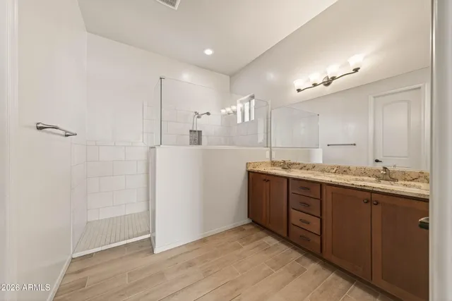 a bathroom with a granite countertop sink mirror and shower