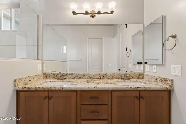 a bathroom with a granite countertop sink and a mirror