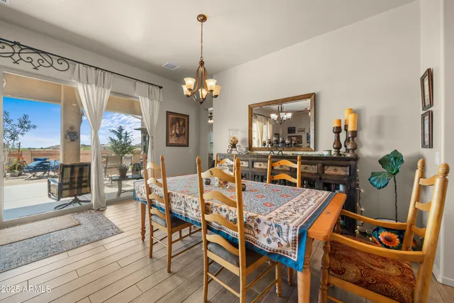 a view of a dining room with furniture a chandelier and wooden floor