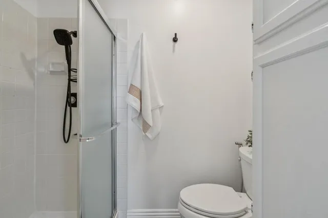 a white toilet sitting next to a shower