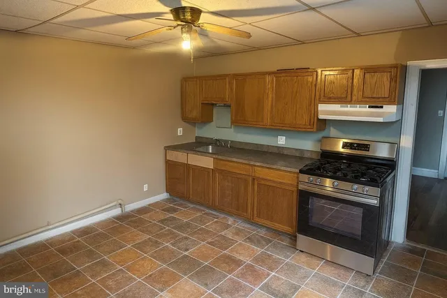 a kitchen with granite countertop a sink cabinets and stainless steel appliances