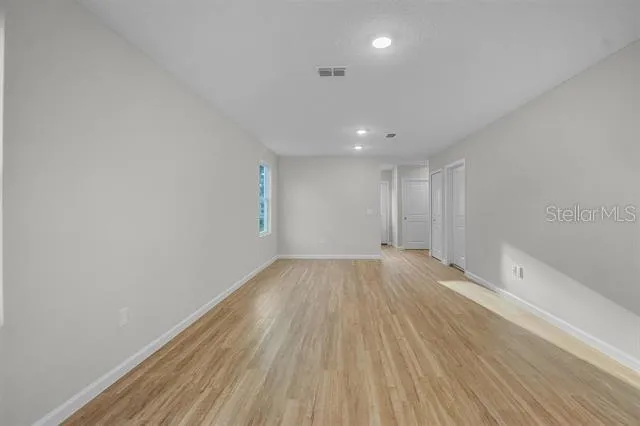 a view of an empty room and wooden floor