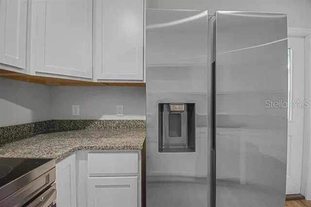 a kitchen with granite countertop cabinets stainless steel appliances and a counter space