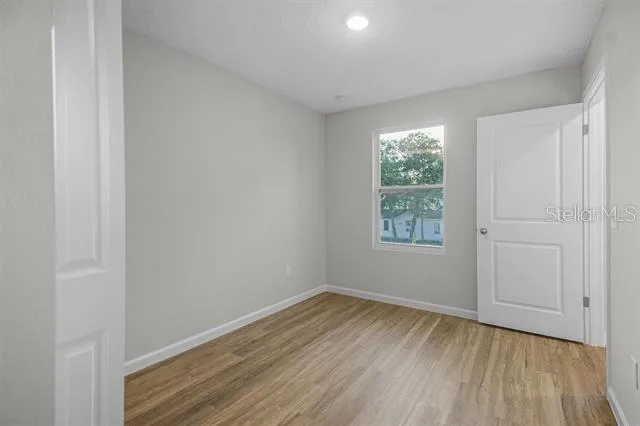 a view of a room that has wooden floor and window in it
