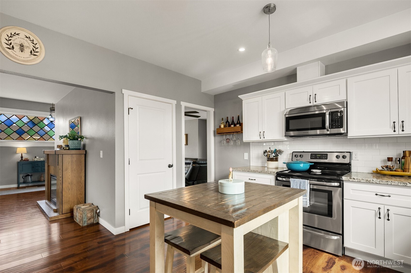 1002 Thompson Street Sumner, WA 98390 - Photo 15 of 38 a kitchen with a sink a microwave a stove and refrigerator
