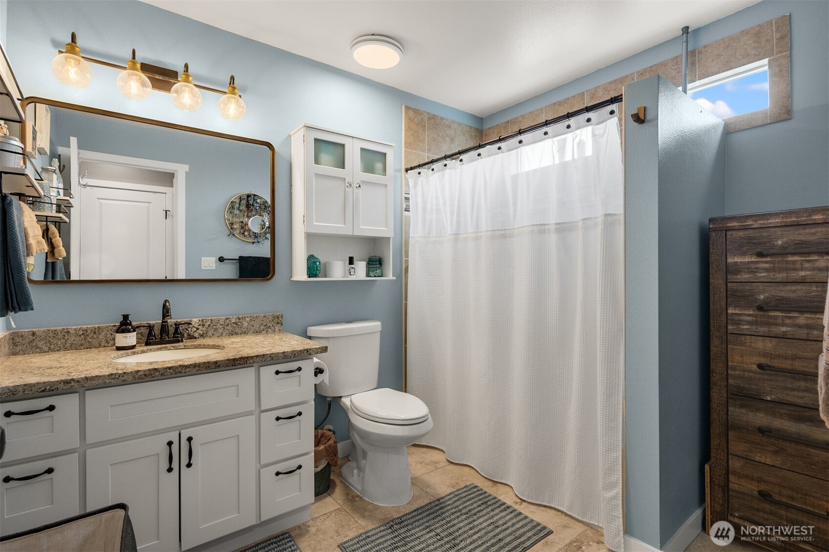 1002 Thompson Street Sumner, WA 98390 - Photo 16 of 38 a bathroom with a toilet sink a mirror a vanity and shower