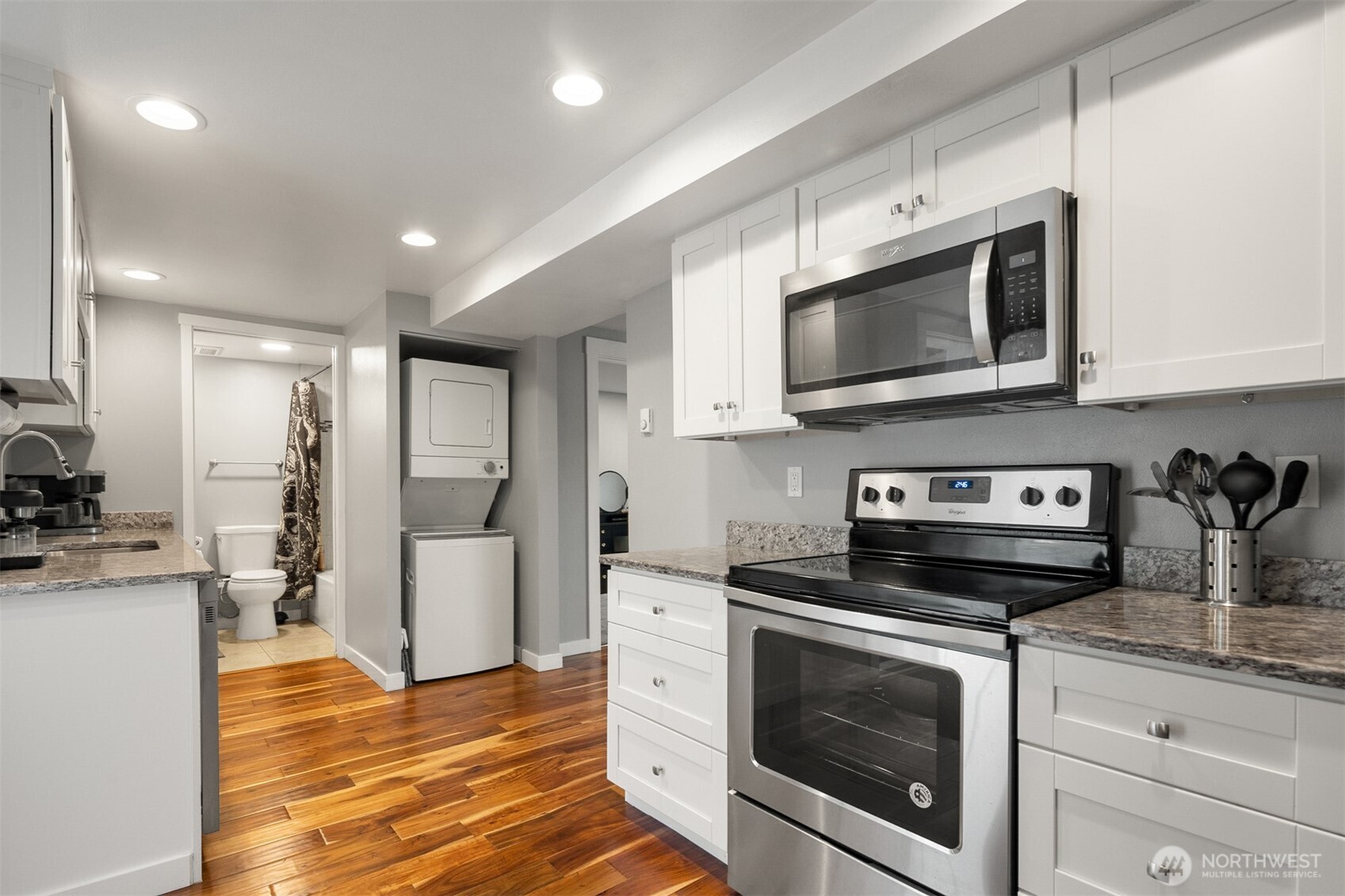1002 Thompson Street Sumner, WA 98390 - Photo 32 of 38 a kitchen with stainless steel appliances granite countertop a stove a microwave and a refrigerator