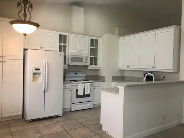 a kitchen with white cabinets and sink