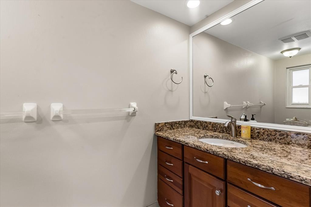 620 Jacaranda Street Dunedin, FL 34698 - Photo 13 of 30 a bathroom with a granite countertop sink and a mirror