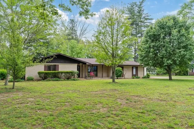a front view of a house with a yard and trees