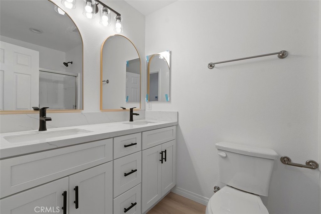 16925 Nanticoke Road Apple Valley, CA 92307 - Photo 24 of 42 a bathroom with a double vanity sink toilet and a mirror