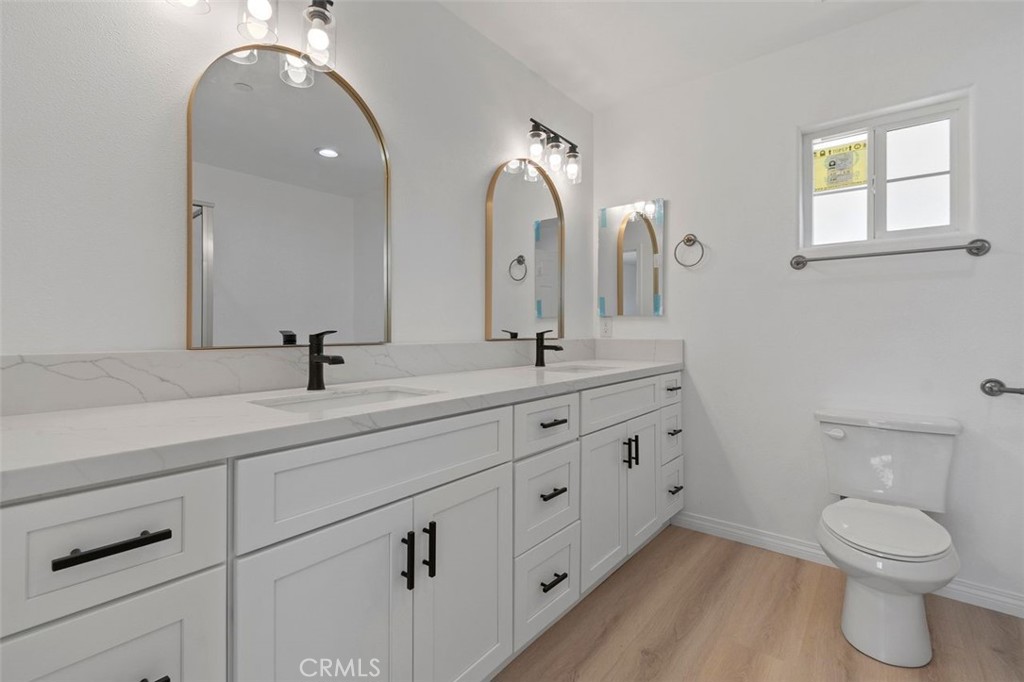 16925 Nanticoke Road Apple Valley, CA 92307 - Photo 29 of 42 a bathroom with a double vanity sink toilet and a mirror