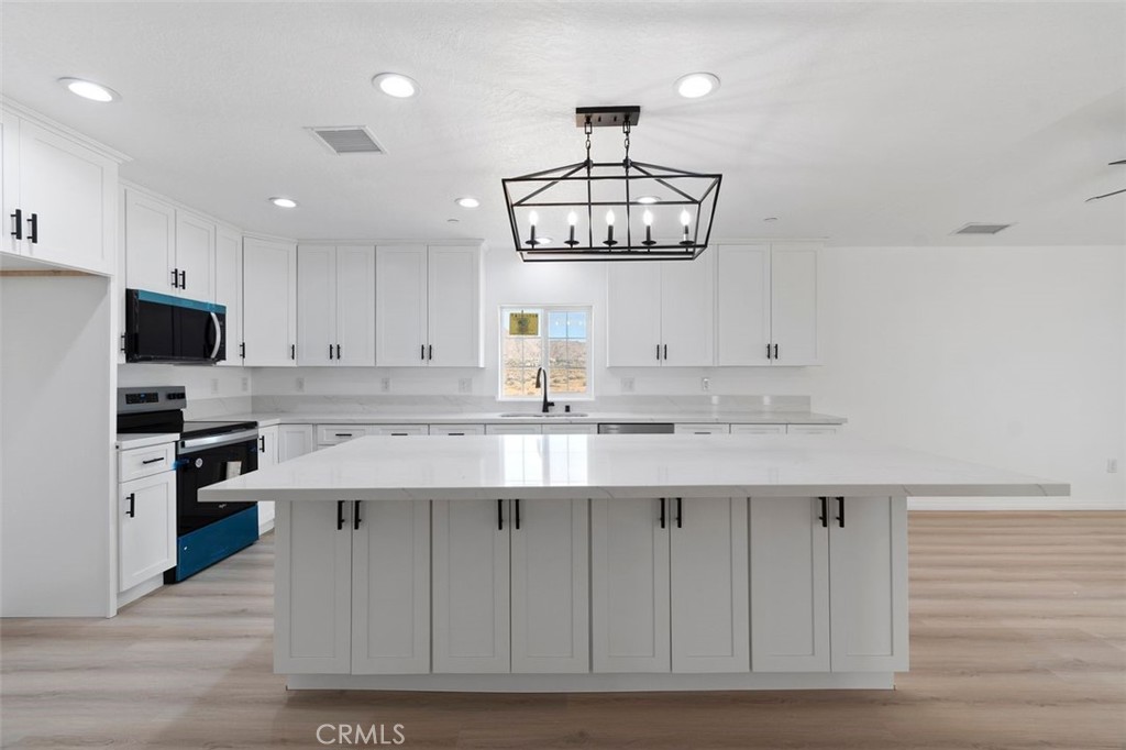 16925 Nanticoke Road Apple Valley, CA 92307 - Photo 36 of 42 a kitchen with a sink stainless steel appliances and chandelier