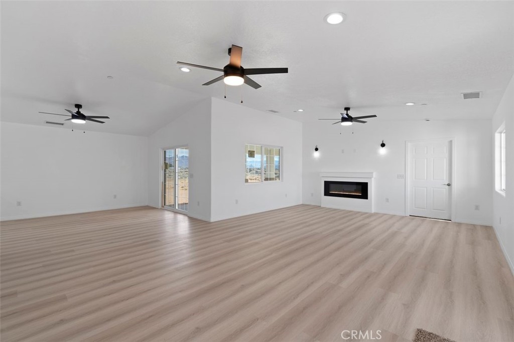 16925 Nanticoke Road Apple Valley, CA 92307 - Photo 39 of 42 an empty room with wooden floor ceiling fan and windows