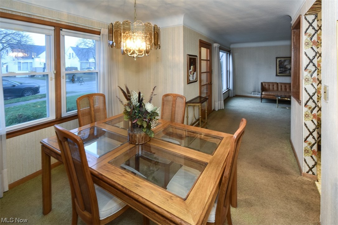 4026 Stonehaven Road Cleveland, OH 44121 - Photo 6 of 30 Carpeted dining space featuring ornamental molding, an inviting chandelier, and a wealth of natural light