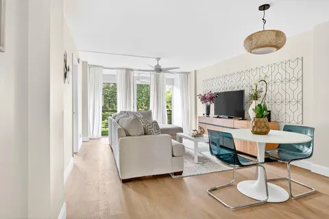 a living room with furniture a flat screen tv and a large window