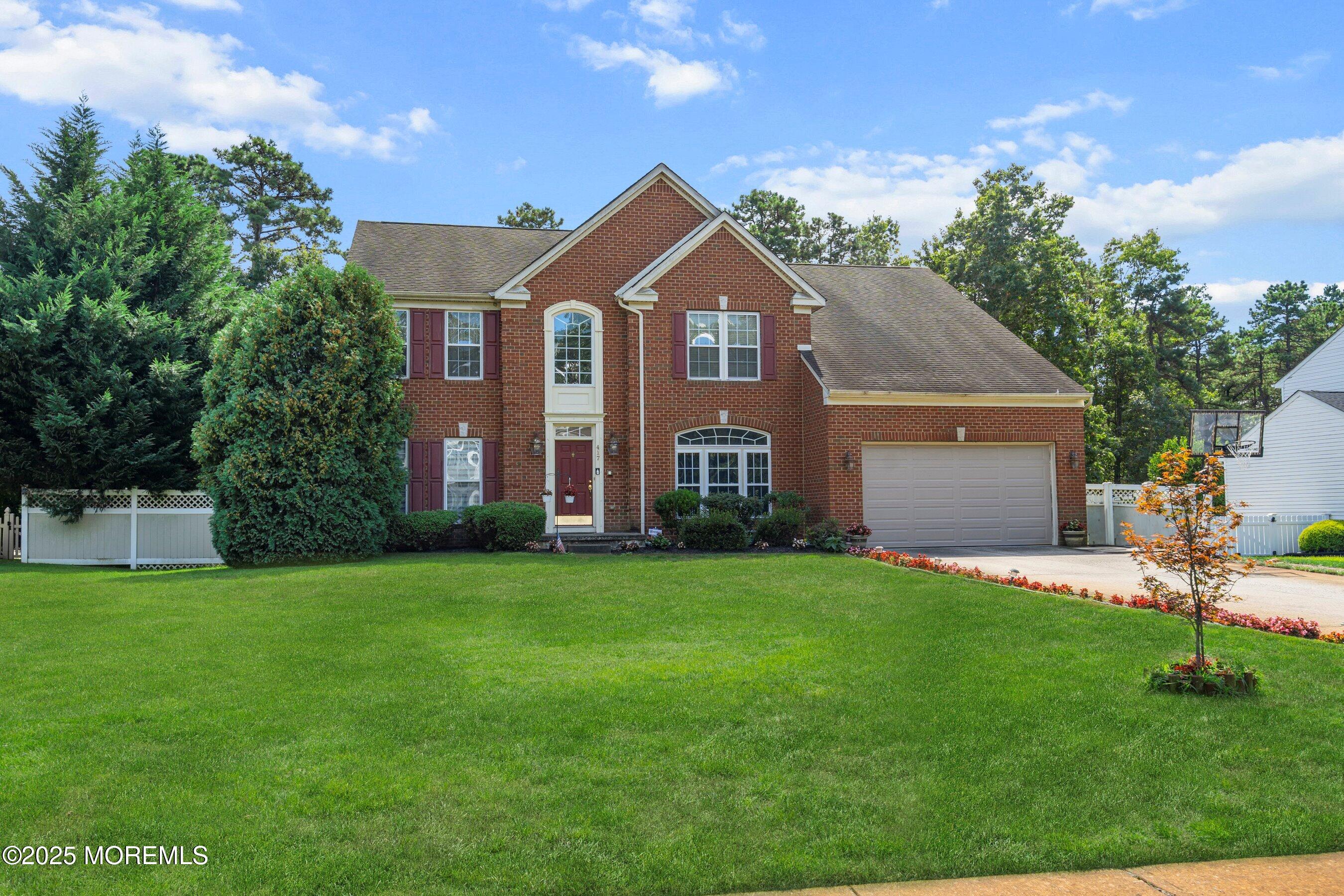 a front view of a house with a yard and trees