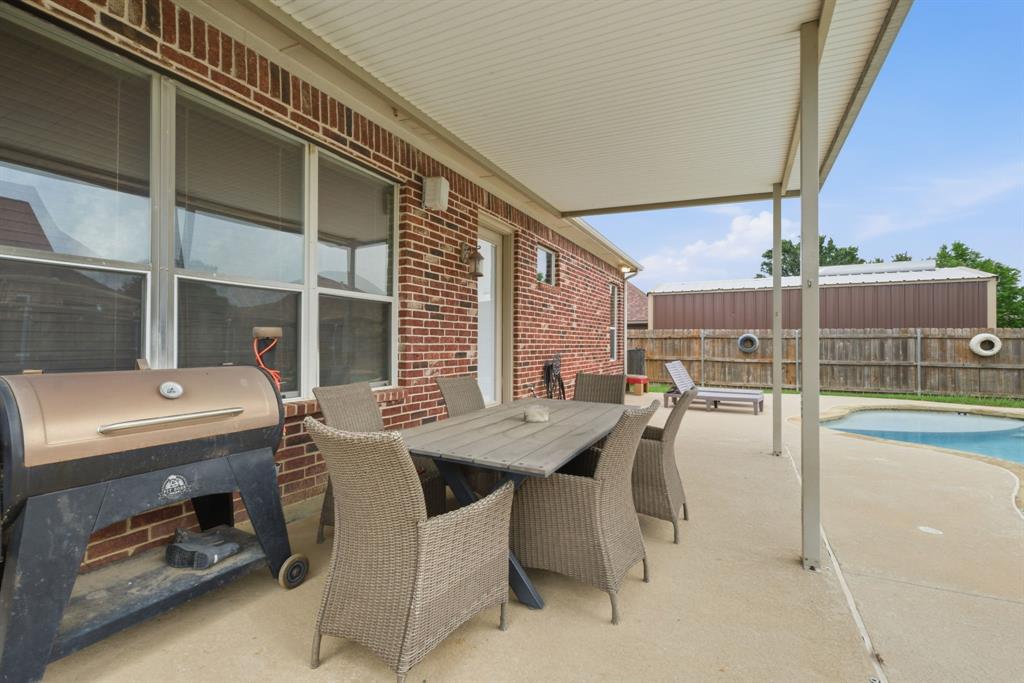 603 Cedar Drive Pilot Point, TX 76258 - Photo 32 of 39 Covered patio with a concrete slab, brick exterior, multiple windows, and direct access to an in-ground swimming pool