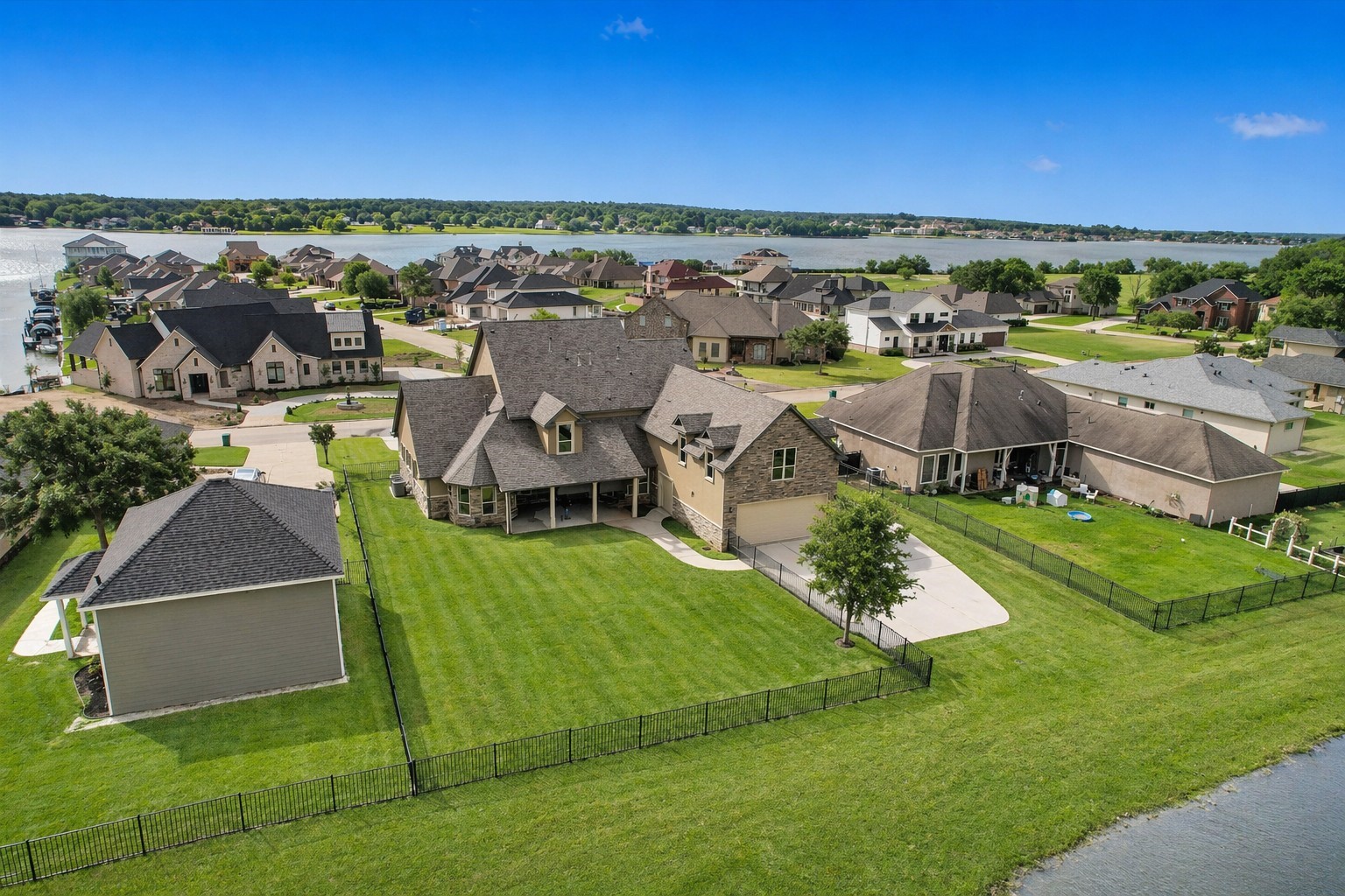 10887 Decatur Street Willis, TX 77318 - Photo 4 of 50 Set on an approximate 14,000 square foot canal-front lot with open views to Lake Conroe, the backyard delivers room to spread out, wrought iron fencing and a peaceful water backdrop with no rear neighbors crowding in.