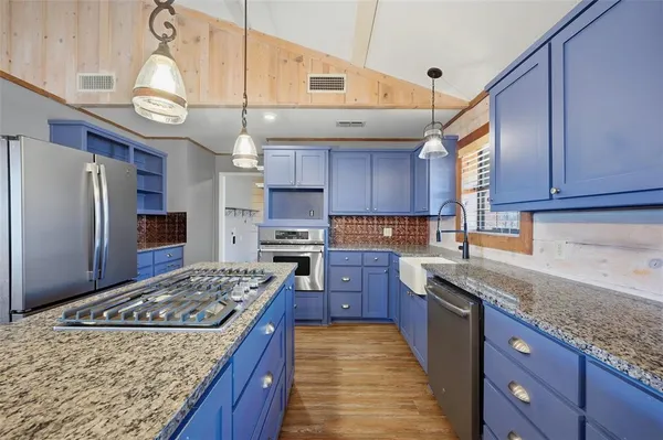 a kitchen with a stove a refrigerator and wooden floor