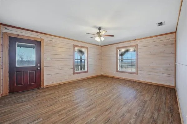 a view of an empty room with wooden floor