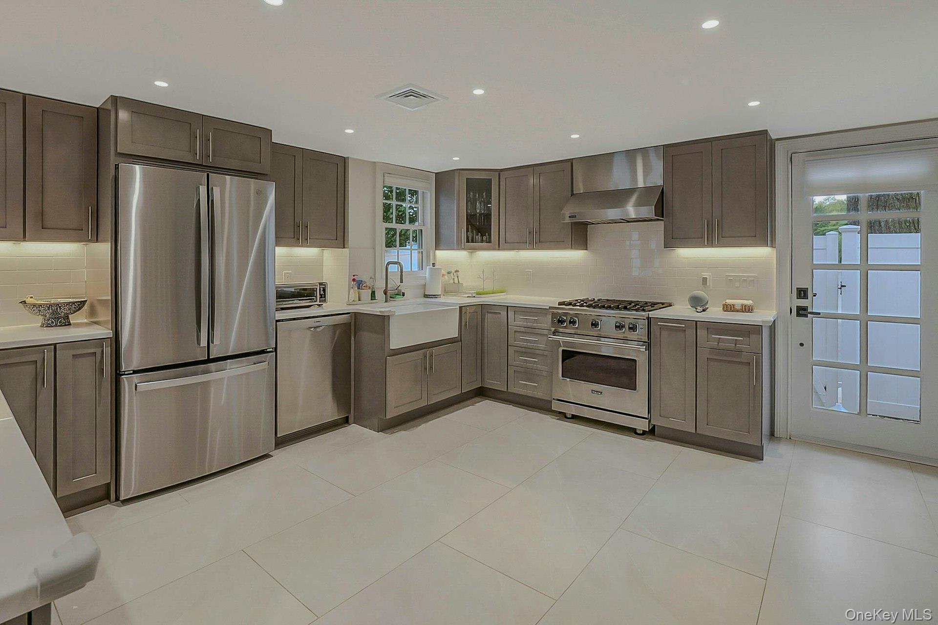 236 Berry Hill Road Syosset, NY 11791 - Photo 7 of 27 Kitchen with appliances with stainless steel finishes, wall chimney range hood, light tile patterned floors, tasteful backsplash, and recessed lighting