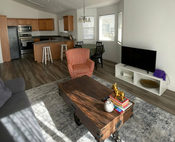 90 East Resaca Drive, Unit C11 Sandy, UT 84070 - Photo 15 of 27 Living room with dark wood-style floors, vaulted ceiling, and a chandelier