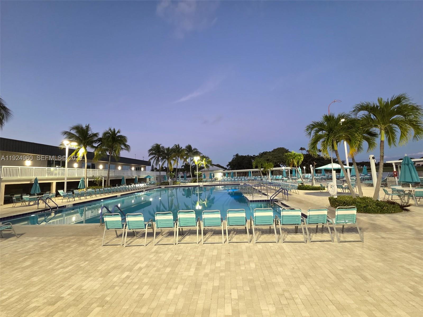 612 Normandy Lane, Unit 612 Delray Beach, FL 33484 - Photo 15 of 18 a view of a lake with a lawn chairs under an umbrella