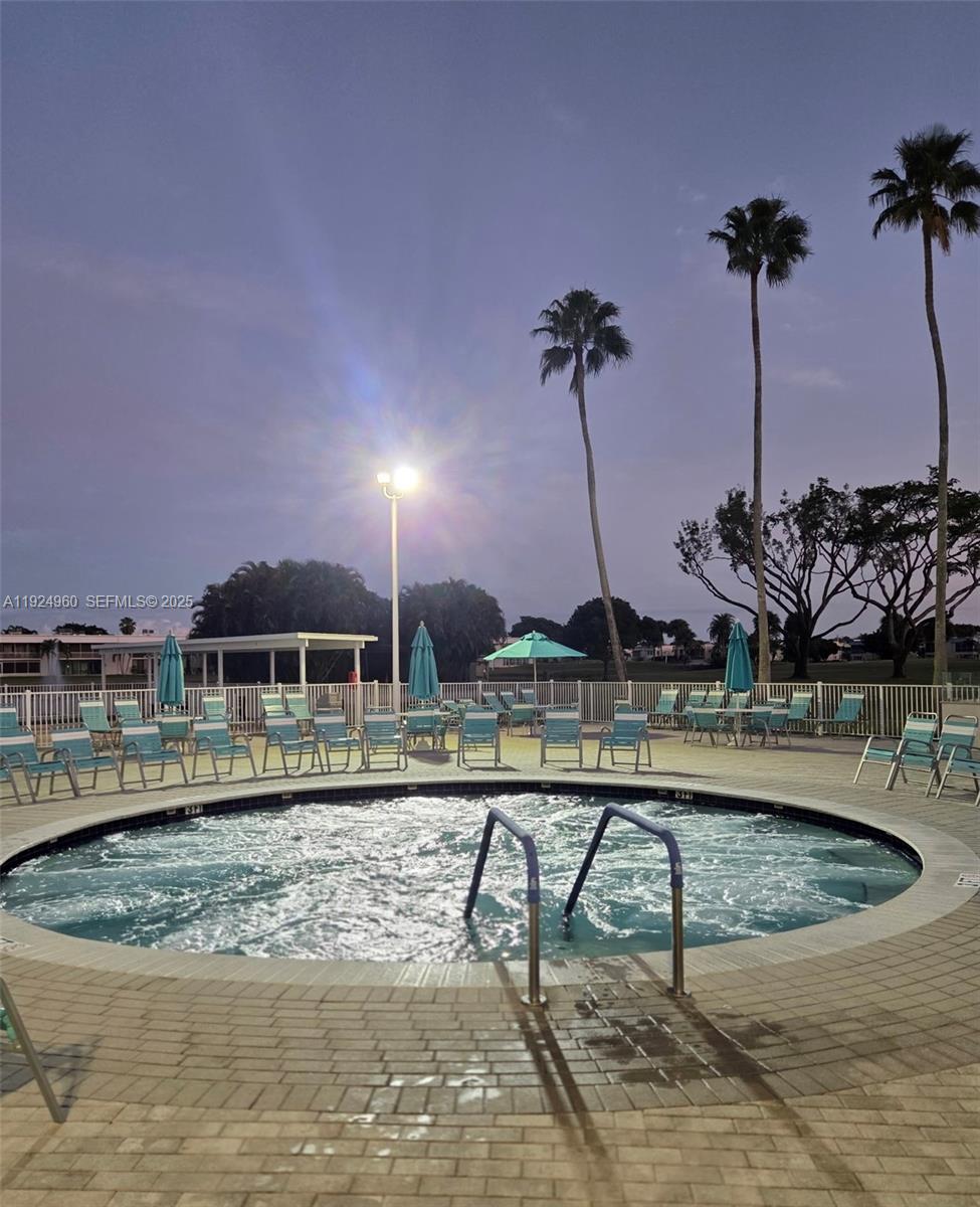 612 Normandy Lane, Unit 612 Delray Beach, FL 33484 - Photo 17 of 18 a view of a house with pool and chairs