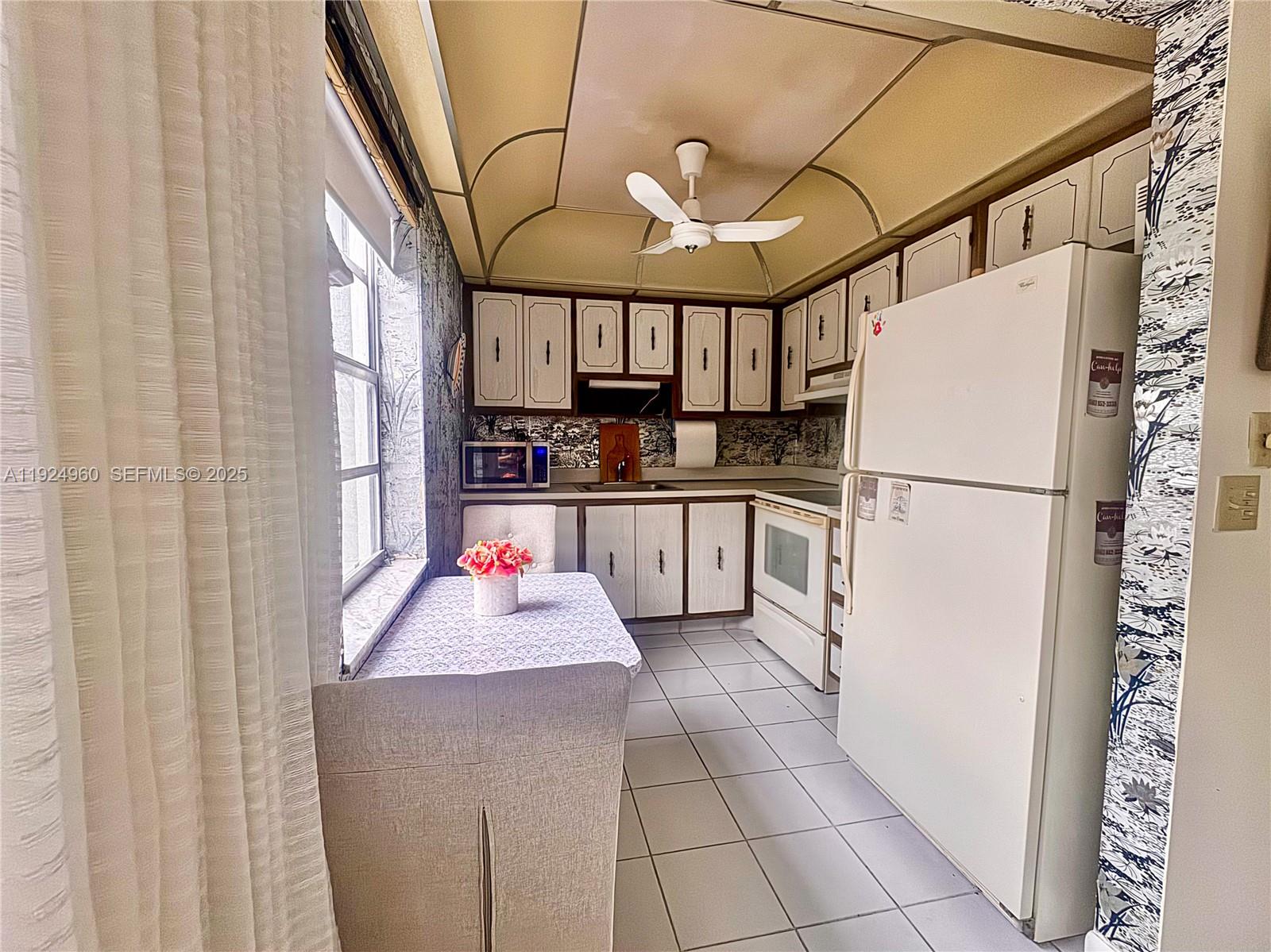 612 Normandy Lane, Unit 612 Delray Beach, FL 33484 - Photo 4 of 18 a kitchen with stainless steel appliances granite countertop a refrigerator and a sink