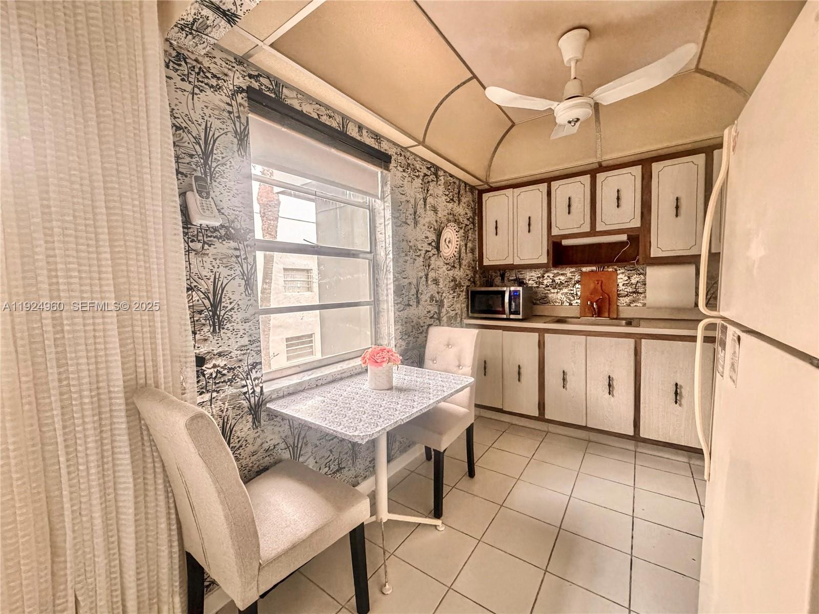 612 Normandy Lane, Unit 612 Delray Beach, FL 33484 - Photo 5 of 18 a kitchen with a table chairs stove and cabinets