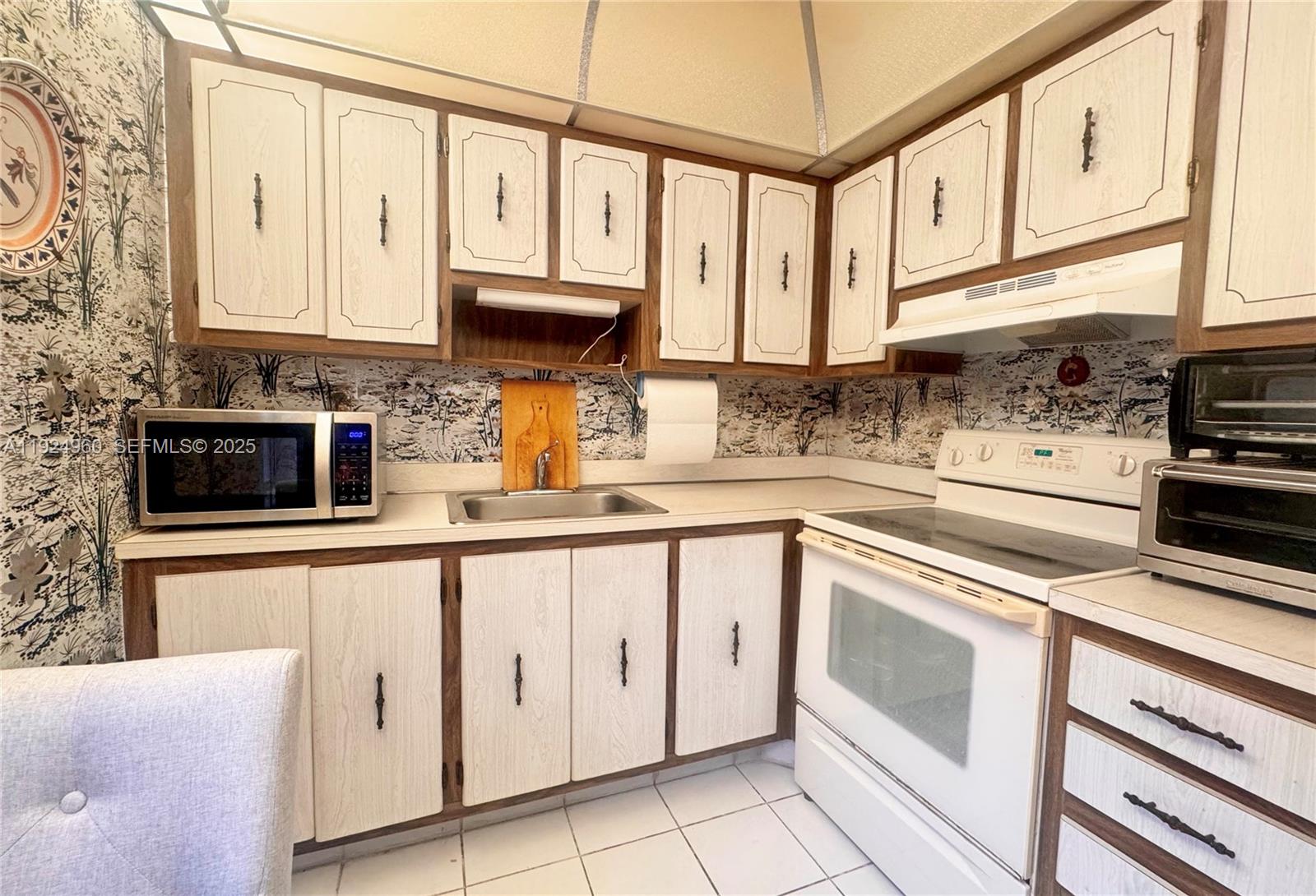 612 Normandy Lane, Unit 612 Delray Beach, FL 33484 - Photo 6 of 18 a kitchen with stainless steel appliances granite countertop a sink and cabinets
