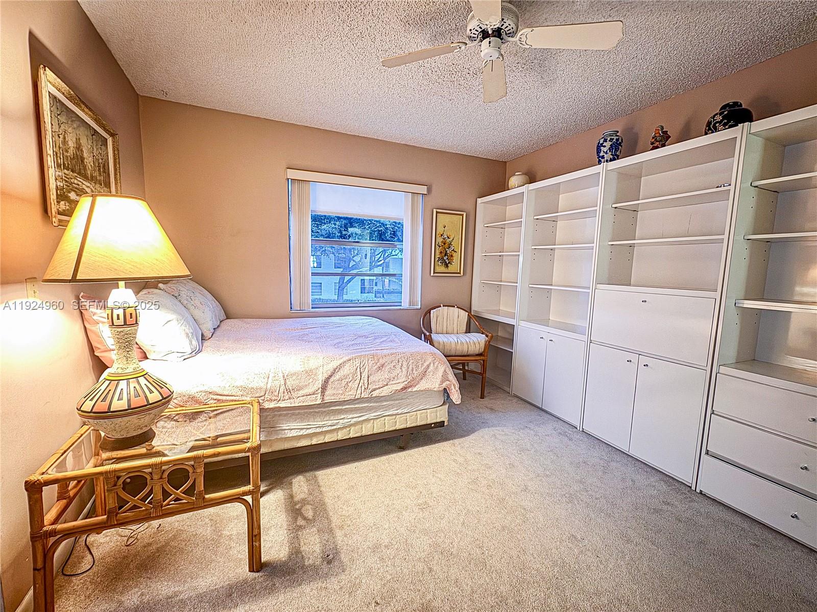 612 Normandy Lane, Unit 612 Delray Beach, FL 33484 - Photo 9 of 18 a bedroom with a bed and a chandelier