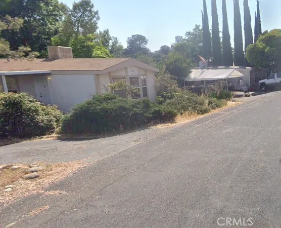 a front view of house with yard and trees around