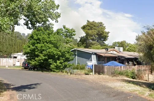 a view of a house with a yard and large trees