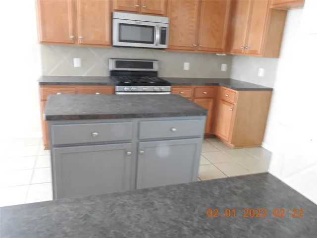 a kitchen with granite countertop cabinets stainless steel appliances and a counter space