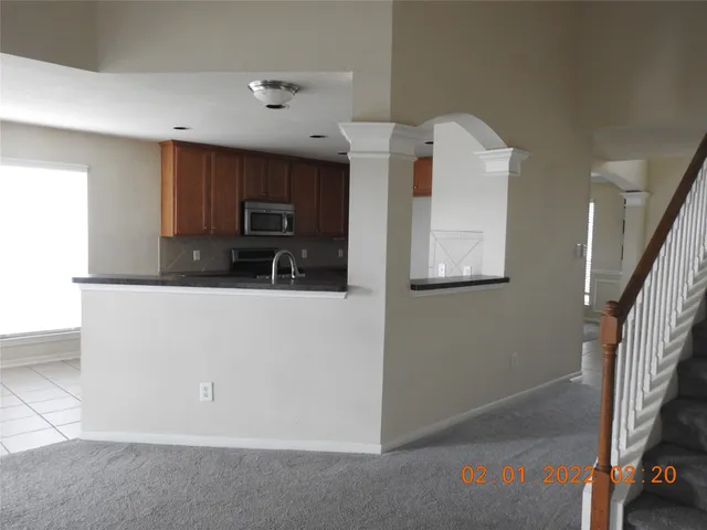 a kitchen with granite countertop a refrigerator and a microwave
