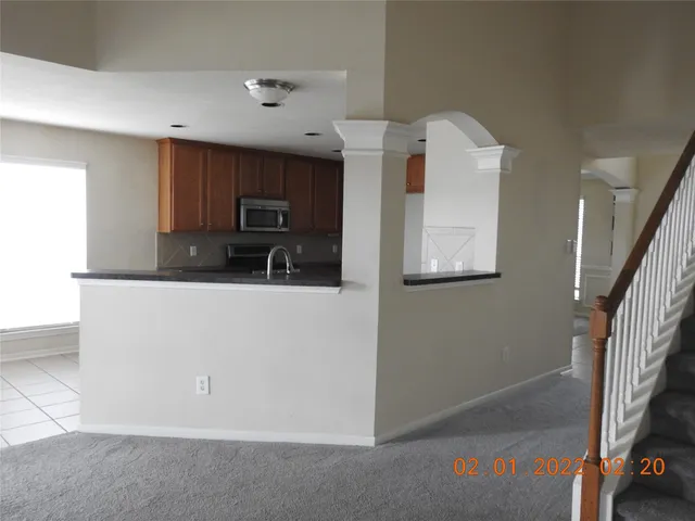 a kitchen with granite countertop a refrigerator and a microwave