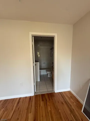 a view of a room with wooden floor and a bathroom