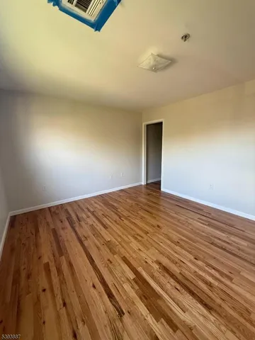 a view of a big room with wooden floor and windows